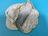 a purse with a hat on top of it on a blue surface