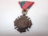 an old medal with a ribbon around it on a white surface