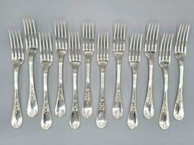 six forks and six knives are arranged in a row on a table