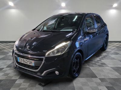 la voiture noire est garée sur un sol en damier dans le garage