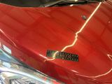 a close up of a red motorcycle with a black sticker on it