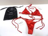 two red bikinis and a drawsack bag on a table
