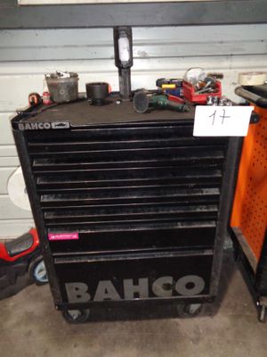 une armoire à outils noire, sur laquelle sont posés des outils, dans un garage