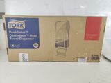emballage d'un distributeur de serviettes en papier Tork posé sur un comptoir