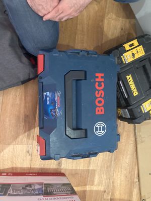 a man kneeling on the floor with a tool box
