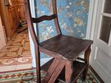 une chaise en bois posée devant une porte dans une pièce
