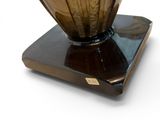 a vase that is sitting on a stand on a white surface