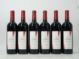 six bouteilles de vin rouge sont alignées sur une table