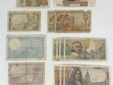 several different types of foreign currency displayed on a white surface