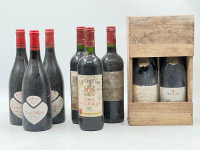 trois bouteilles de vin rouge dans un coffret en bois orné d'un cœur sur le côté
