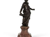 une statue en bronze représentant une femme tenant un enfant dans ses bras, posée sur un socle
