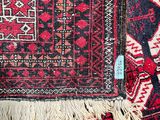 a close up of a red and black rug with a blue tag