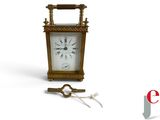 a small clock with a key attached to it