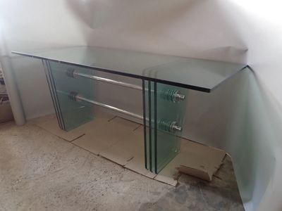 an image of a glass desk in a corner of a room