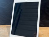 an ipad is sitting on a wooden table with a black background