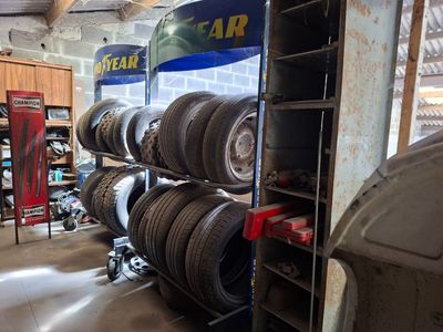de nombreux pneus empilés sur un support dans un garage