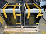 two microwaves sitting on a pallet in a warehouse