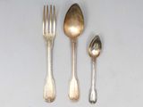 three silver spoons and two silver spoons on a table