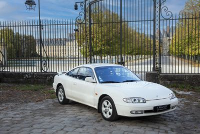 une voiture blanche garée devant un portail