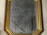 un miroir posé sur le sol à côté d'un mur