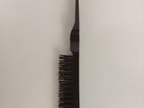 a black comb and a black comb on a white table