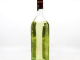 a green bottle with a brown cap sitting on a white surface