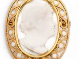 an antique gold broochle with a white stone in the center