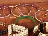 many different bracelets and bangles on a table