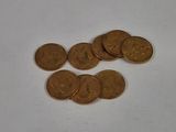 a pile of coins sitting on a table next to a cell phone