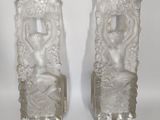 pair of clear glass vases with figures on them on a white background