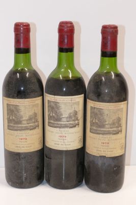 trois bouteilles de vin posées sur une table blanche