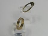 pair of gold wedding rings on clear acrylic stand