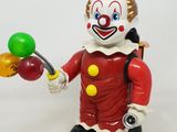 clown en jouet tenant un bouquet de ballons sur fond blanc