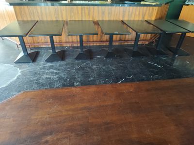 trois tables et un banc au milieu d'une pièce