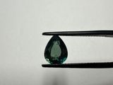 a close up of a pair of pliers holding a green diamond