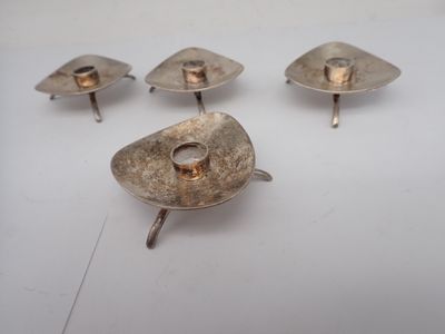 several silver candlesticks with a gold ring on top of them