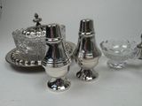 a silver tea set on a table next to a bowl and plate