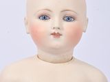 a small doll that is sitting on a white surface