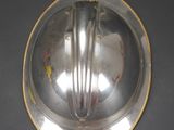 an antique silver plate with a handle on a black surface