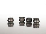 trois vases en argent posés sur une surface blanche