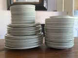 a lot of plates stacked on a table in the kitchen