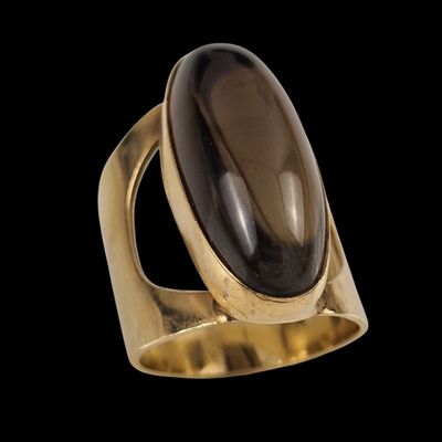 une bague en or ornée d'une grosse pierre noire au centre