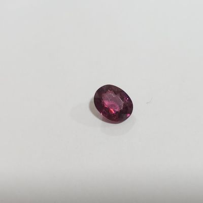 un gros plan d'un saphir rose posé sur une surface blanche