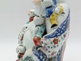 a figurine of a woman with a dog on her lap