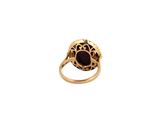 a close up of a gold ring with a red stone