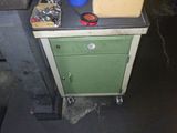 a green cabinet with a stove top and a blue bucket