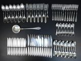 a lot of silver spoons and silverware on a table