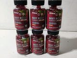 six bottles of beet root sit on a white surface
