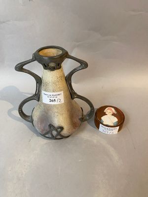 a small vase with a tag on it next to a small bowl