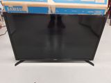 a black television sitting on top of a table next to a box